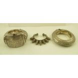 A SUBSTANTIAL WHITE METAL BEDOUIN BRACELET of hinged design, having pegged clasp, together with