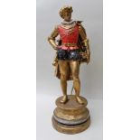 A SPELTER FIGURE OF A MEDIEVAL KNIGHT in ruff and red tunic, cape and dress sword, mounted on