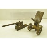 AN EARLY 20TH CENTURY TIN PLATE SPRING ACTION FIELD ARTILLERY GUN, on two spoked wheels, and SIMILAR