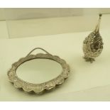 AN EASTERN WHITE METAL FRAMED SMALL MIRROR of oval form with embossed floral decoration and chain