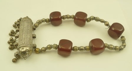 AN EASTERN, POSSIBLY BEDOUIN NECKLACE, set cube form dark red beads, possibly amber