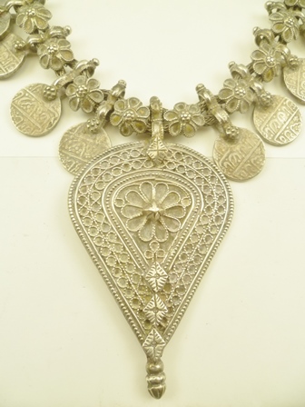 A BEDOUIN WHITE METAL NECKLACE decorated with coins, alternating with flower heads, suspending a - Image 2 of 5