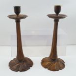 A PAIR OF CARVED STAINED WOOD CANDLESTICKS OF ART NOUVEAU DESIGN with scrolling pedestal bases, 31cm