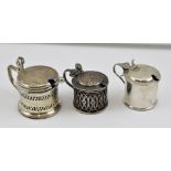 THREE VARIOUS SILVER MUSTARD POTS of Georgian design, drum form, each with blue glass liner