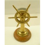 A BRASS MODEL OF A SHIP'S WHEEL inset with a compass, on polished wood base, 13cm high