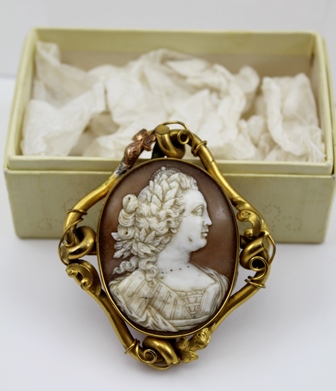 AN EARLY 19TH CENTURY GILT METAL MOUNTED SHELL CAMEO BROOCH, carved with a female bust, possibly