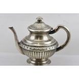 A FOREIGN SILVER COLOURED METAL COFFEE POT having tubular handle with ivory spacers, on a foliate