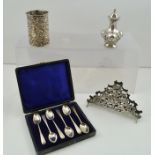 A SELECTION OF SILVER ITEMS comprising; a baluster repousse pepperette, a pressed bottle sleeve, a