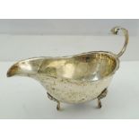 BISHTONS LTD. A SILVER SAUCEBOAT having cut and crimped rim, up-scrolled handle with acanthus