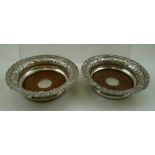 PROBABLY CHARLES PRICE A PAIR OF GEORGE III SILVER COASTERS each having possibly later repousse work