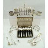 AN EARLY 20TH CENTURY SILVER TOAST RACK, Chester 1911, together with SIX SILVER NAPKIN RINGS, a pair