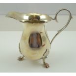 J. GLOSTER LTD. A SILVER CREAM JUG, having wavy rim, plain scrolling handle and plain baluster body,