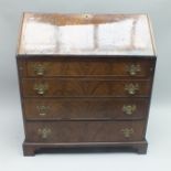 A 19TH CENTURY MAHOGANY BUREAU having flame veneered fall-down writing slope revealing a part fitted