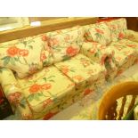 A PAIR OF MODERN TWO-SEATER SOFA'S with bright floral printed cotton fabric upholstery with plain