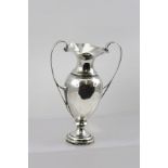 AN EDWARDIAN SILVER URN FORM VASE with two applied handles, on circular platform base, London