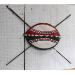 TWO MASAI METAL SPEARS and a painted MASAI HIDE SHIELD, mounted as a wall ornament (provenance