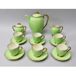 A CARLTON WARE NINE PIECE COFFEE SET, each green ground with gilt rim and pearlescent interior,