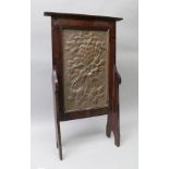 A 20TH CENTURY ARTS & CRAFTS STAINED WOOD FIRESCREEN with inset beaten copper panel decorated with