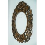 AN EARLY 20TH CENTURY CHINESE CARVED WOOD MIRROR OR PICTURE FRAME, oval reserve, carved and