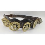 A LEATHER MARTINGALE STRAP with six horse brasses, includes a fox mask