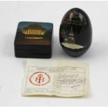 A RUSSIAN LACQUERED BOX of ovoid form, painted and inscribed with a church in the snow, 7cm high,