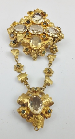 A VICTORIAN YELLOW METAL BROOCH of floral and petal form, inset with citrines, comprising two