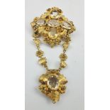A VICTORIAN YELLOW METAL BROOCH of floral and petal form, inset with citrines, comprising two