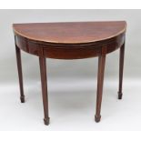 A REGENCY MAHOGANY DEMI-LUNE FOLD OVER CARD TABLE, raised on squared tapering spade foot supports,
