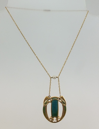 AN ART NOUVEAU DESIGN PENDANT, enamel inlaid yellow metal, suspended from a chain set with a Baroque