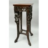 AN ORIENTAL CARVED PADOUK WOOD JARDINIERE STAND, raised upon four outswept supports, height 61cm