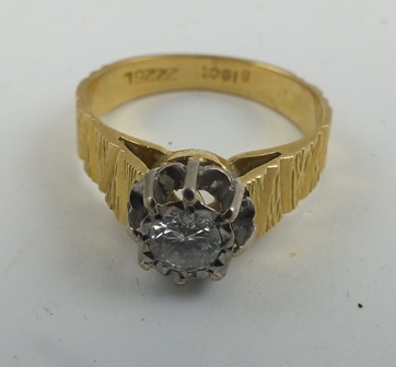 A SOLITAIRE DIAMOND RING, highly set, mounted upon a bark effect 18ct gold band, size M 1/2