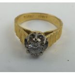 A SOLITAIRE DIAMOND RING, highly set, mounted upon a bark effect 18ct gold band, size M 1/2