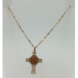 A 1982 GOLD HALF SOVEREIGN SET IN A YELLOW METAL PENDANT of cross form, on a 9ct gold long link neck