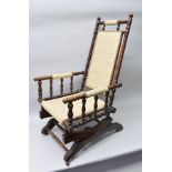 A LATE 19TH/EARLY 20TH CENTURY TURNED WOODEN FRAMED AMERICAN STYLE ROCKING ARMCHAIR, with