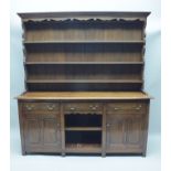 AN EARLY 20TH CENTURY OAK DRESSER having triple shelved plate rack back, over three in-line drawers,