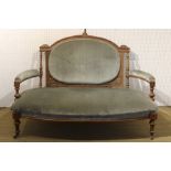 AN EDWARDIAN CARVED SHOW-WOOD OPEN ARM TWO SEATER SOFA, with upholstered oval back pad, arm pads and