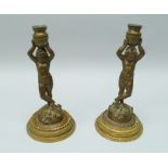 A PAIR OF 19TH CENTURY BRONZE CANDLESTICKS, the stems in the form of classical figures holding aloft
