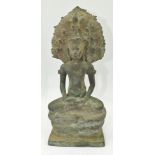 AN 18TH CENTURY KHMER BRONZE BUDDHA, seated upon a Mandarla snake throne with a Naga background,