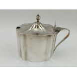 PETER & ANN BATEMAN A GEORGE III SILVER MUSTARD POT of serpentine form, with hinged cover and blue
