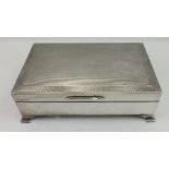 AN ART DECO DESIGN SILVER CIGARETTE BOX, hinged engine turned cover, cedar lined, raised on