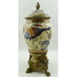 A LATE 19TH CENTURY POTTERY VASE AND COVER, painted with exotic birds amidst flowers, cast gilt