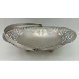 WILLIAM HENRY LEATHER A PIERCED SILVER CAKE BASKET, with swing handle, raised on four ball feet,