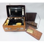 A LATE VICTORIAN TRAVELLING VANITY CASE containing various glass jars with silver lids, a brass