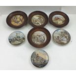 A COLLECTION OF SEVEN PRATTWARE POT LIDS, four oak framed, and three unframed (7)