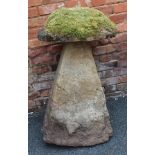 AN EARLY STADDLE STONE, having circular cap and tapering angular base, the base stands 86cm high,