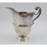 GOLDSMITHS & SILVERSMITHS CO. LTD. AN EDWARDIAN SILVER CREAM JUG of Georgian design, having scroll