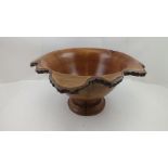 A TURNED TREEN BOWL, the flared rim with bark edge, on circular platform base, 21cm high