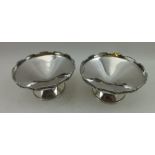 A E POSTON & CO A PAIR OF ART DECO SILVER NUT DISHES, having castellated rims on conical platform