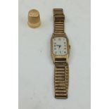 A 9CT GOLD CASED WRISTWATCH of Tank design, canted rectangular dial with Arabic numerals and