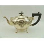 HENRY MATTHEWS A LATE VICTORIAN SILVER TEAPOT having repousse floral decoration, ebonised handle and